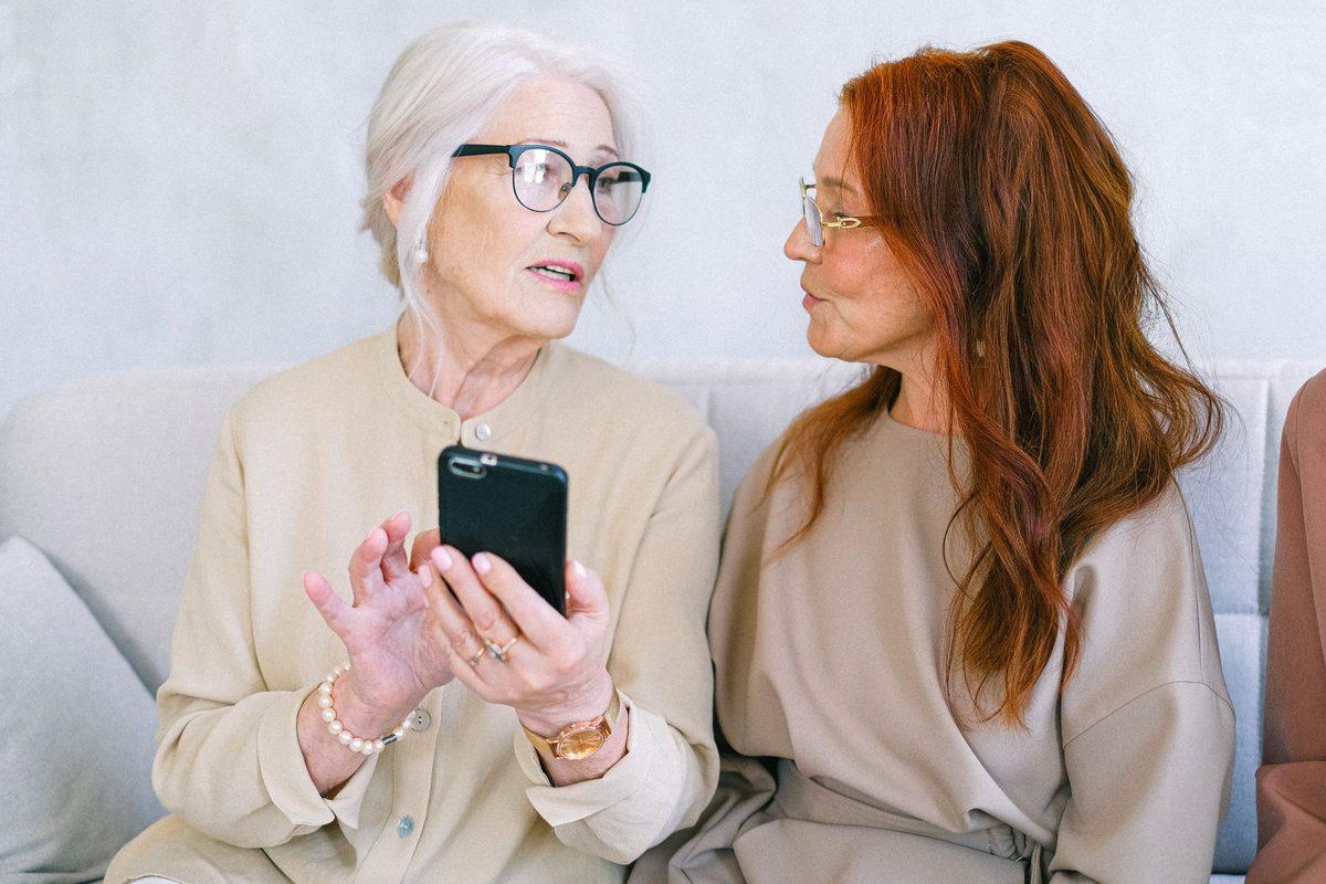Two older women looking at a phone together